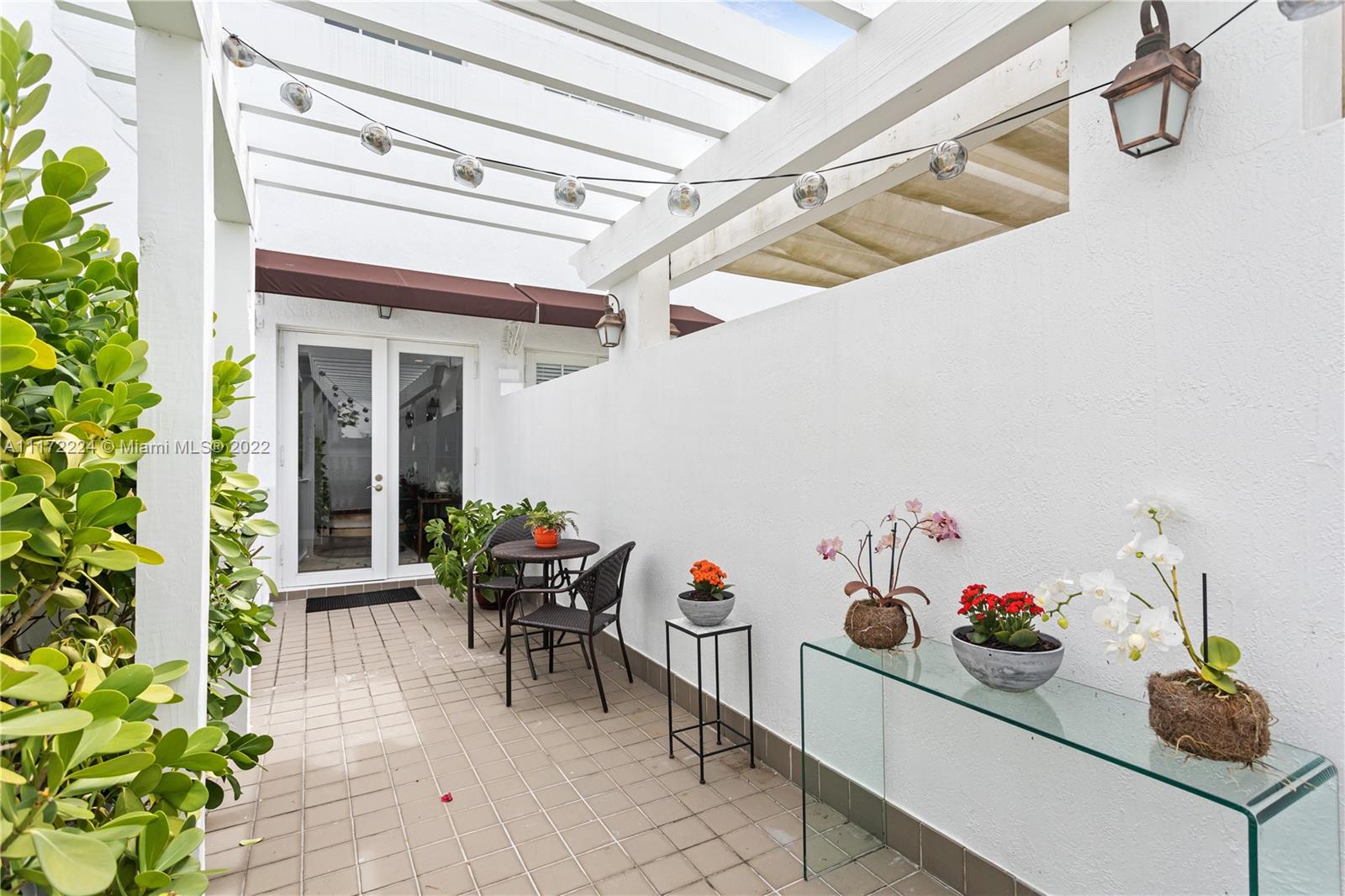 7682 Southwest 54th Avenue Miami, FL 33143 - Photo 32 of 37 a view of a dining room with a table and chairs potted plants