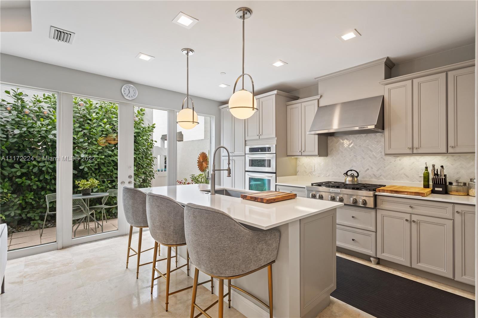 7682 Southwest 54th Avenue Miami, FL 33143 - Photo 9 of 37 a kitchen with stainless steel appliances granite countertop a stove a sink a refrigerator a center island with a dining table and chairs