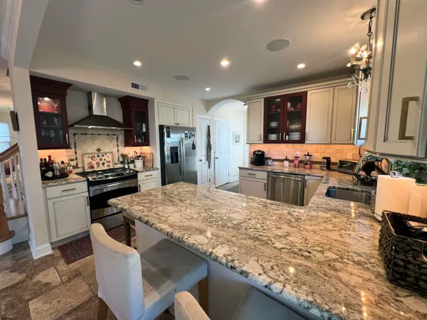 a kitchen with stainless steel appliances kitchen island granite countertop a stove and a refrigerator