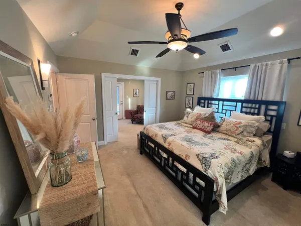 a bedroom with a bed and dresser with wooden floor