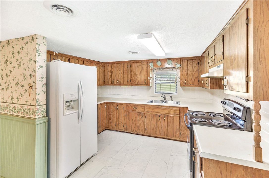 1004 Wiles Road Anderson, SC 29625 - Photo 11 of 26 A well-lit kitchen with natural wood cabinetry and resilient flooring awaits your culinary touch.