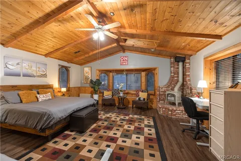 a bedroom with bed and wooden floor