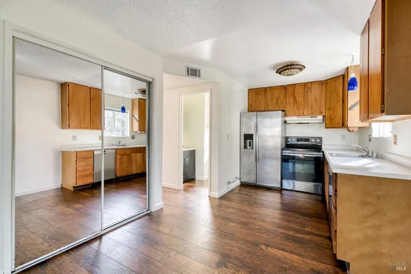 a kitchen with stainless steel appliances a stove a sink and a refrigerator