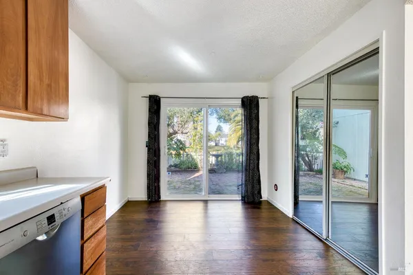 a view of a kitchen with wooden floor and a window