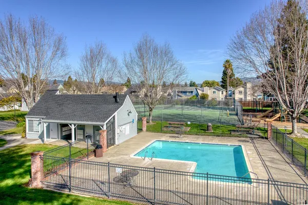 a view of house with yard swimming pool and green space