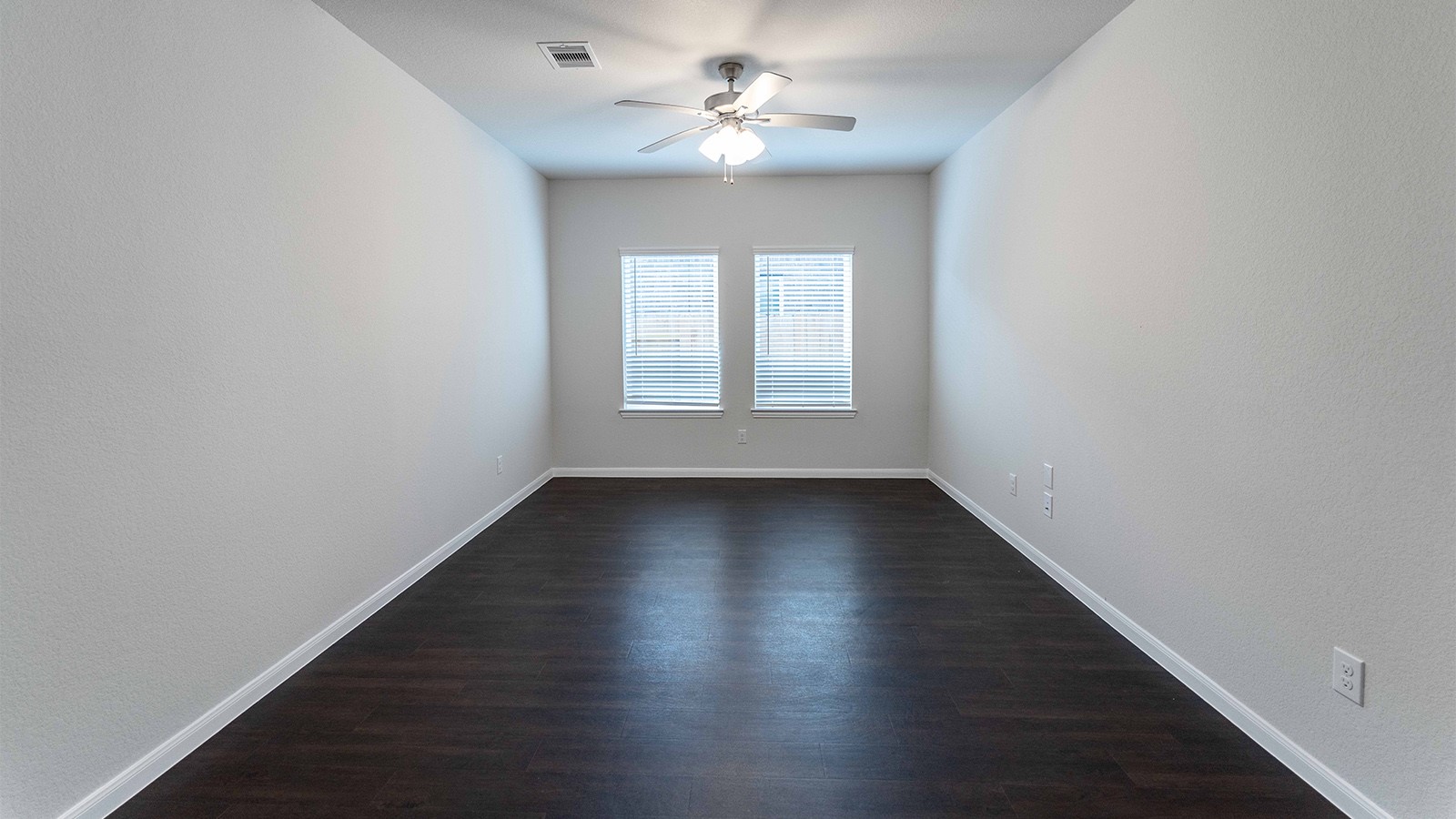 22003 Blue Sky Way New Caney, TX 77357 - Photo 13 of 15 an empty room with wooden floor chandelier fan and windows