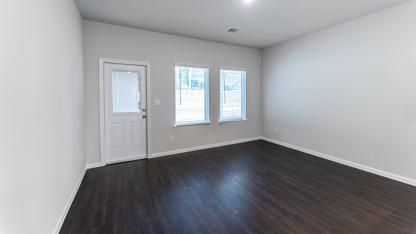 22003 Blue Sky Way New Caney, TX 77357 - Photo 7 of 15 an empty room with wooden floor and windows
