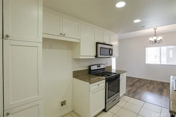 a kitchen with white cabinets and white appliances