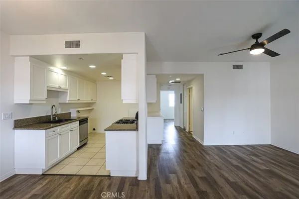 a kitchen with granite countertop a stove a sink and a refrigerator