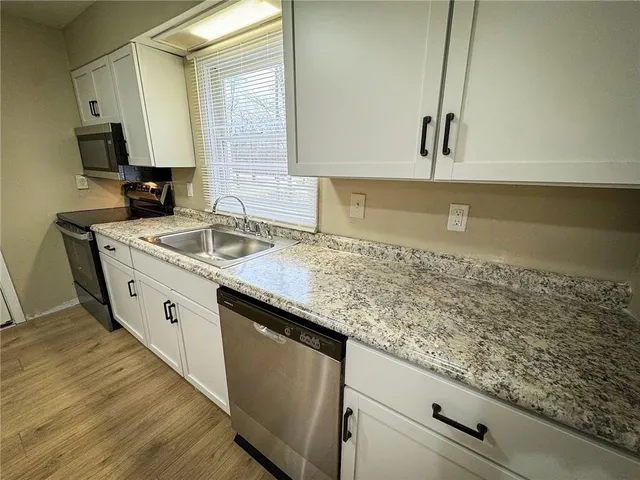 a kitchen with a stove a microwave and window