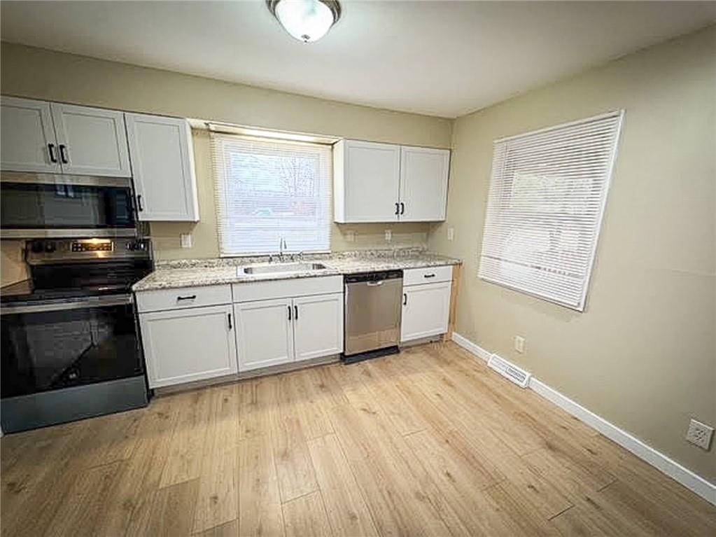 1975 Oneida Valley Road Karns City, PA 16041 - Photo 16 of 35 a kitchen with stainless steel appliances granite countertop a stove a sink and white cabinets
