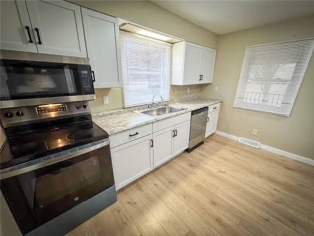 a view of a kitchen with microwave and cabinets