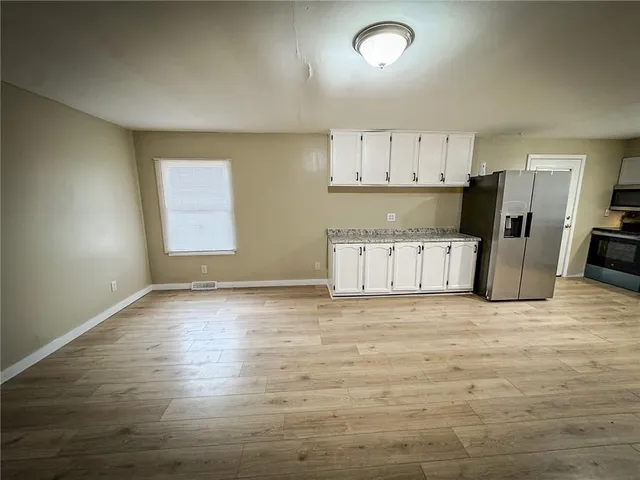 an empty room with a window and wooden floor