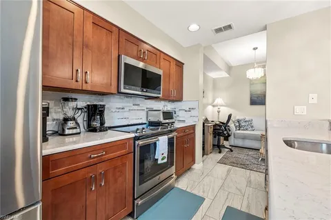 a kitchen with stainless steel appliances granite countertop a stove a sink and a microwave