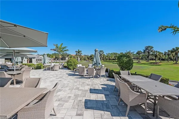 a view of a patio with lawn chairs under an umbrella