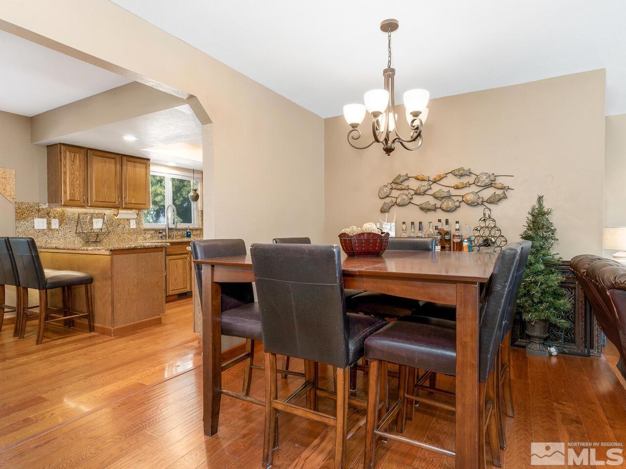 10060 Raintree Court Reno, NV 89511 - Photo 11 of 37 a dining room with furniture a chandelier and wooden floor