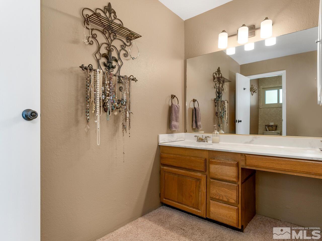 10060 Raintree Court Reno, NV 89511 - Photo 18 of 37 a bathroom with a double vanity sink mirror and shower