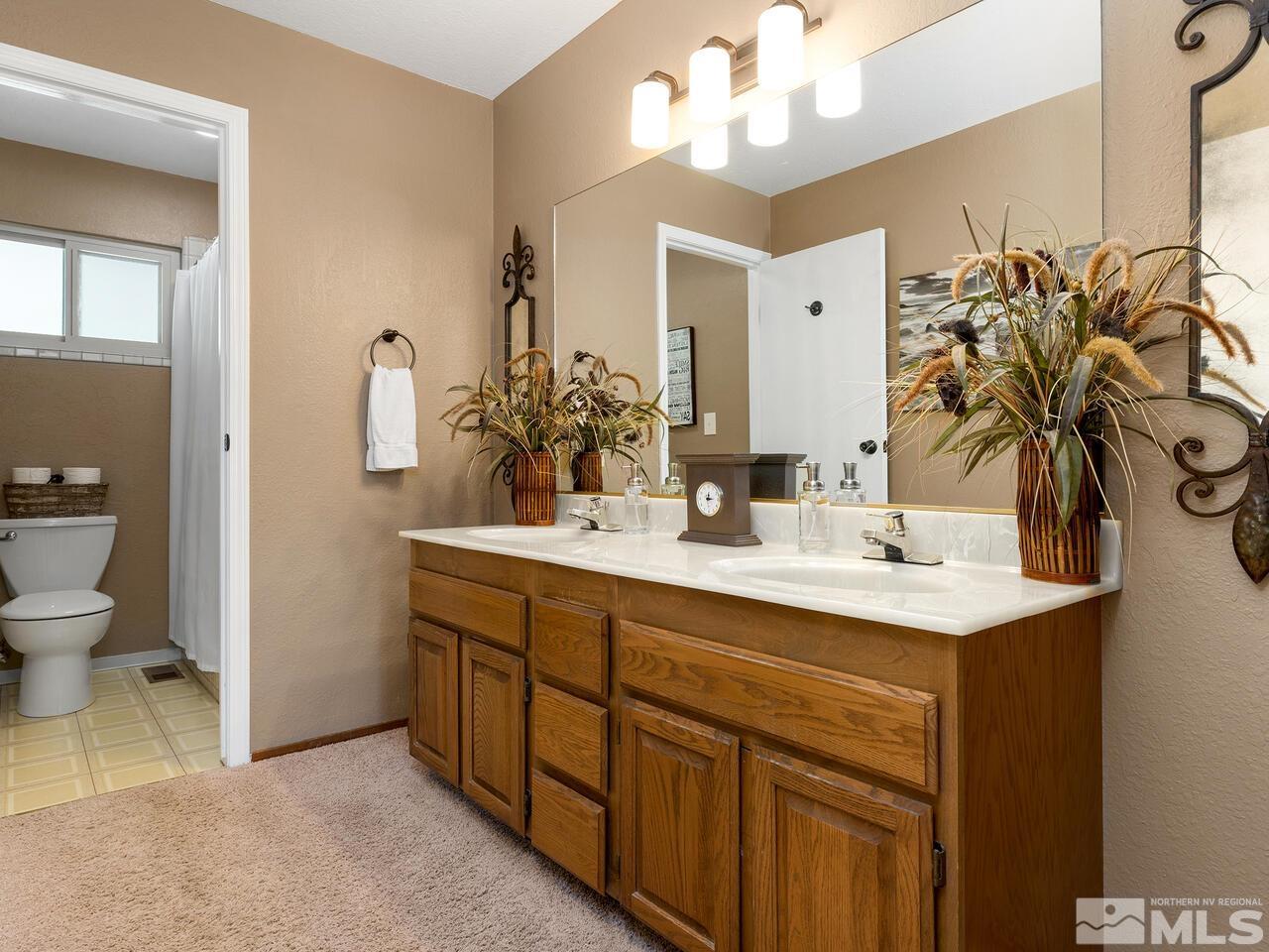 10060 Raintree Court Reno, NV 89511 - Photo 22 of 37 a bathroom with a sink a toilet and a mirror