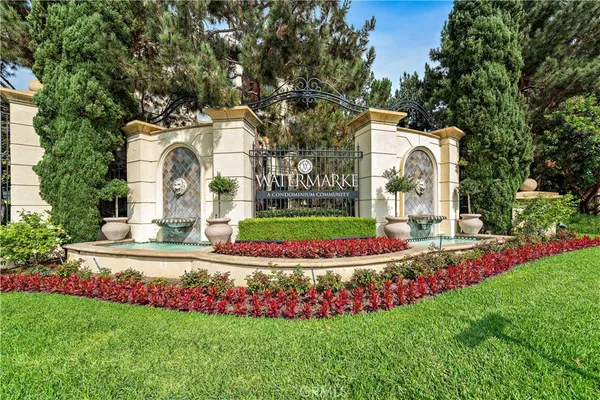 a front view of a house with a garden and trees