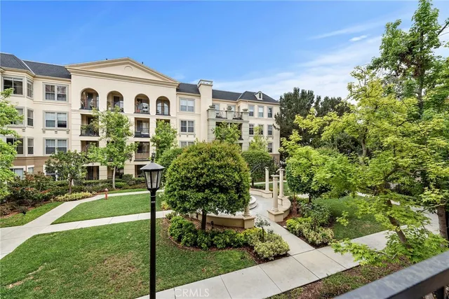 a front view of a house with a yard and fountain in middle