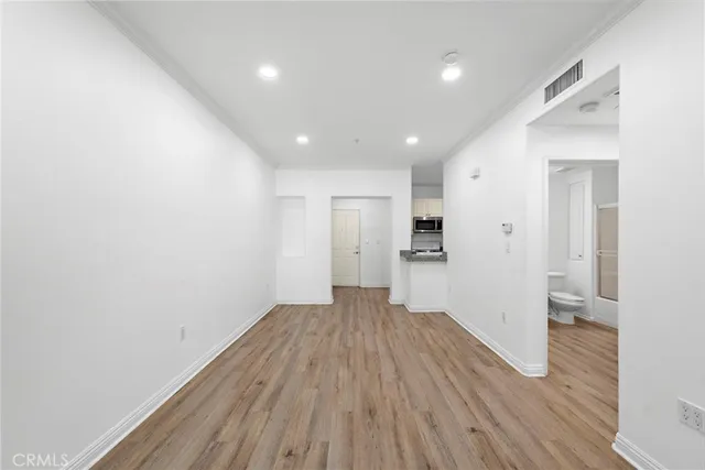 a view of a big room with wooden floor and windows