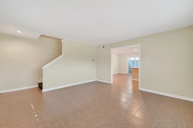 a view of an empty room with closet and a window