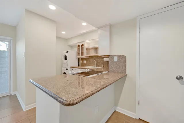 a kitchen with stainless steel appliances granite countertop a sink and a refrigerator
