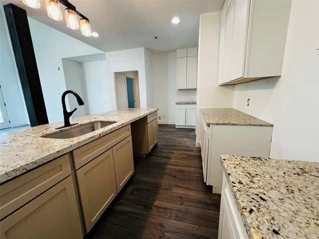 a kitchen with sink cabinets and wooden floor