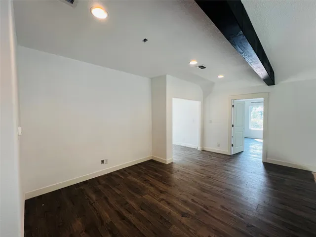 an empty room with wooden floor and entrance