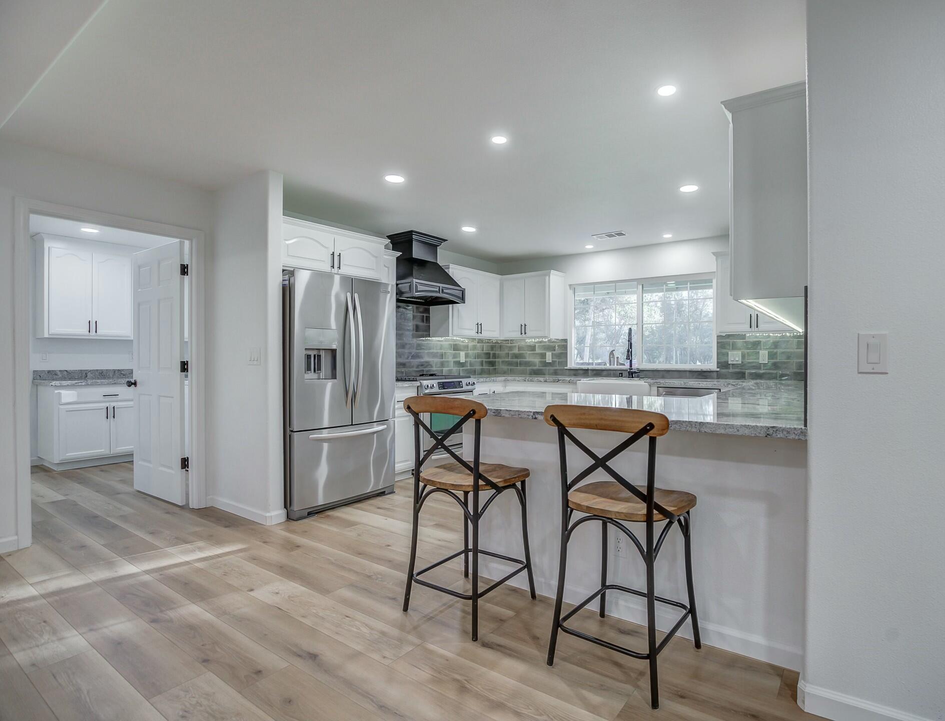 14300 Molluc Drive Red Bluff, CA 96080 - Photo 24 of 48 a kitchen with stainless steel appliances kitchen island granite countertop a refrigerator and cabinets