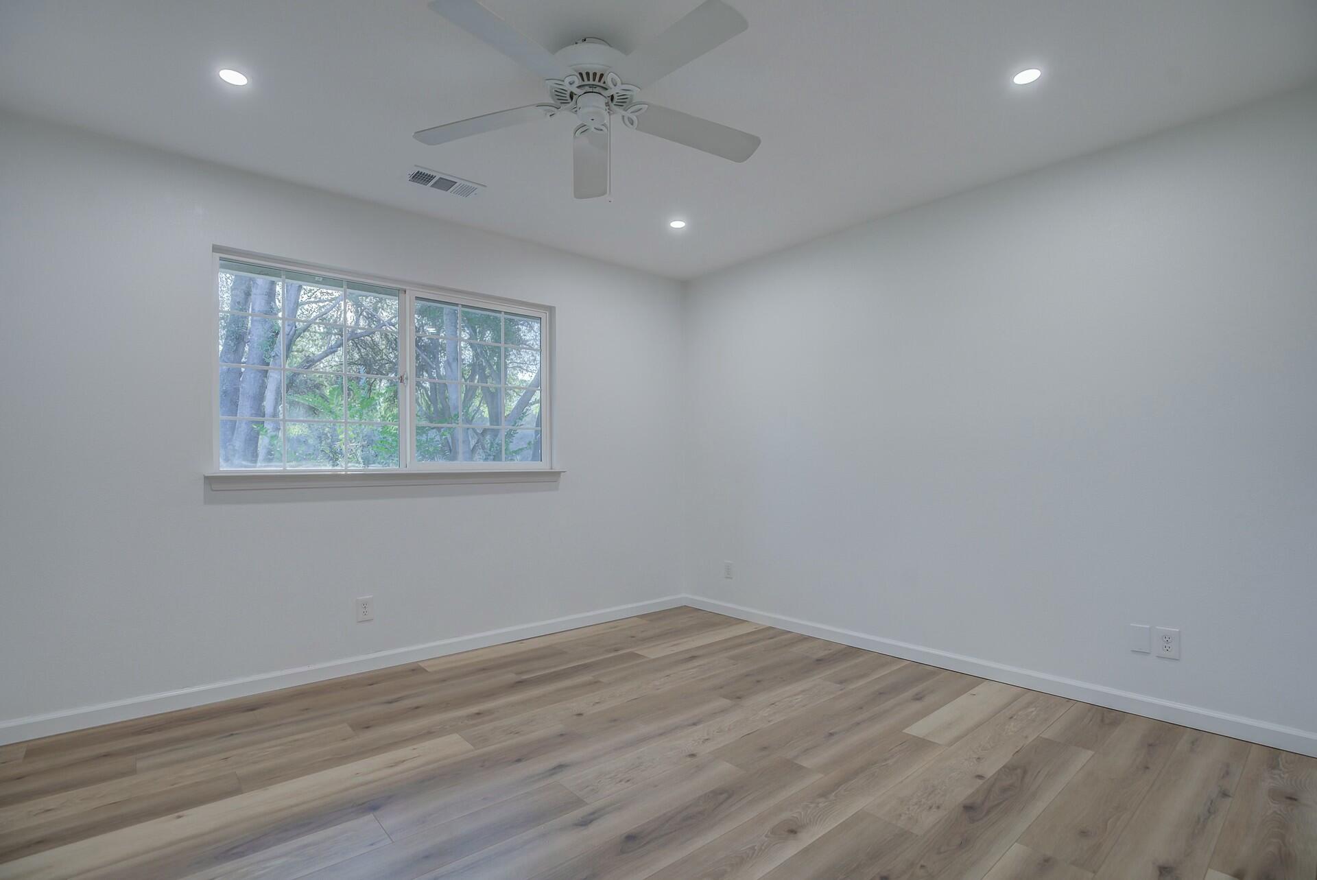14300 Molluc Drive Red Bluff, CA 96080 - Photo 35 of 48 an empty room with wooden floor and windows