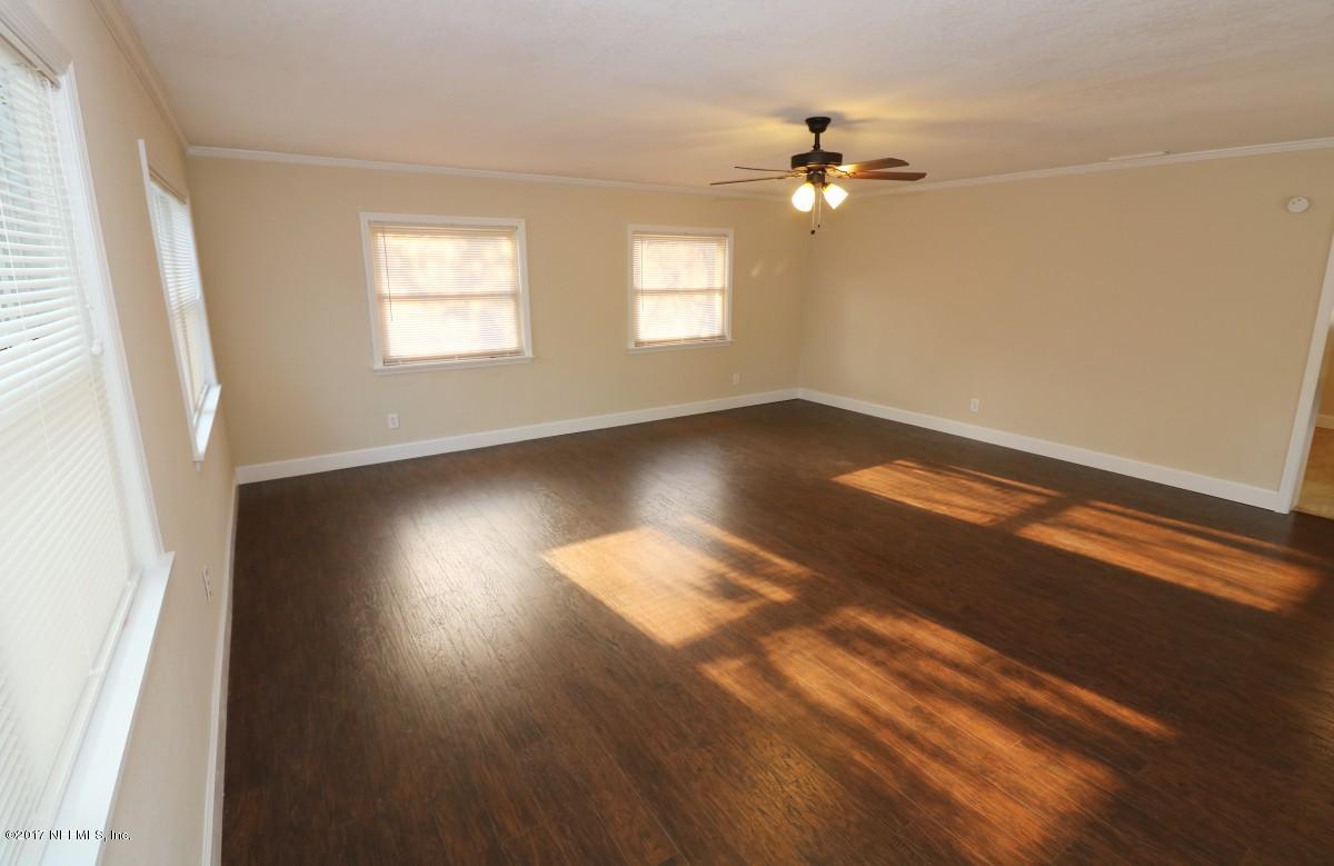 8584 Old Plank Road Jacksonville, FL 32220 - Photo 14 of 23 an empty room with wooden floor and windows