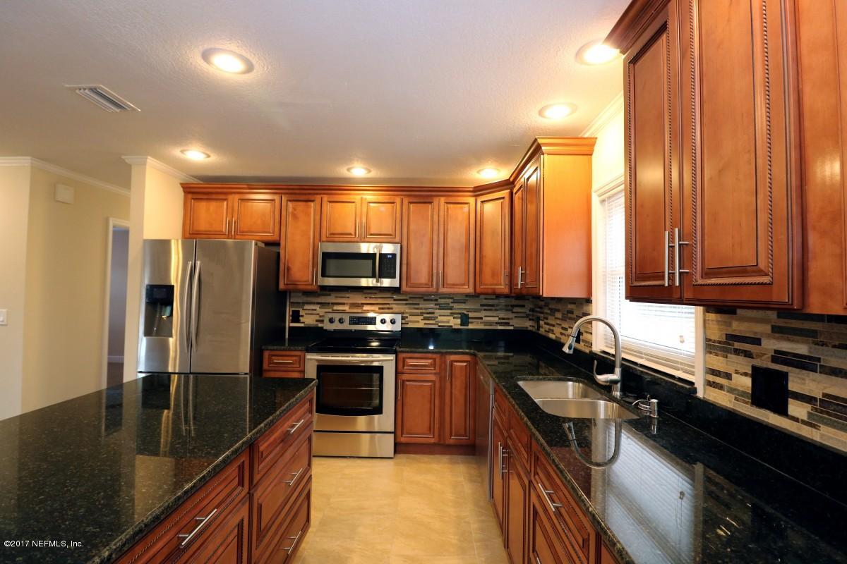 8584 Old Plank Road Jacksonville, FL 32220 - Photo 19 of 23 a kitchen with stainless steel appliances granite countertop a stove top oven a sink dishwasher a refrigerator and cabinets with wooden floor