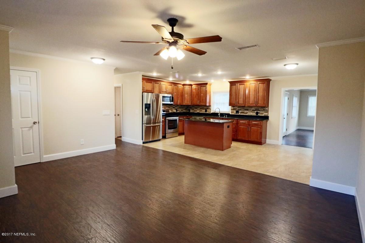 8584 Old Plank Road Jacksonville, FL 32220 - Photo 21 of 23 an open kitchen with wooden floor and stainless steel appliances