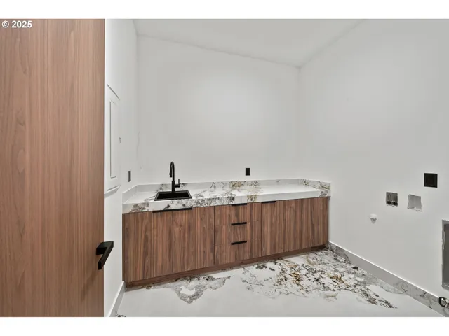 a view of an empty room with wooden floor and windows