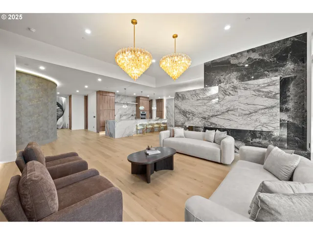 a living room with furniture kitchen view and a chandelier