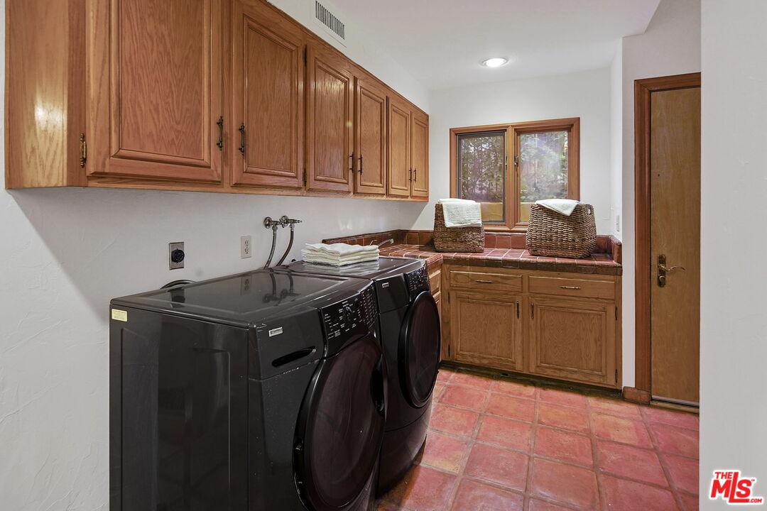 16814 Oak View Drive Encino, CA 91436 - Photo 37 of 49 a utility room with stainless steel appliances granite countertop a sink a stove a washer and dryer