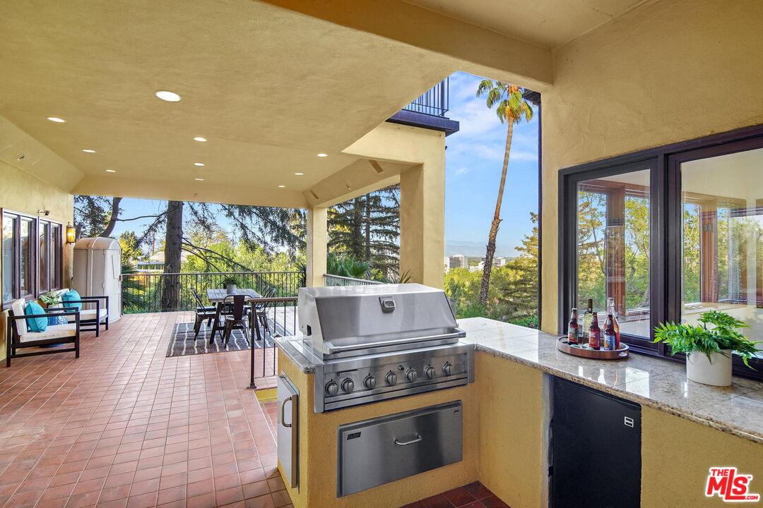 16814 Oak View Drive Encino, CA 91436 - Photo 38 of 49 a kitchen with a table chairs stove and wooden floor