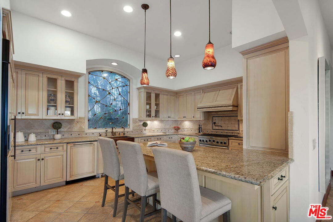 16814 Oak View Drive Encino, CA 91436 - Photo 9 of 49 a kitchen with white cabinets and sink