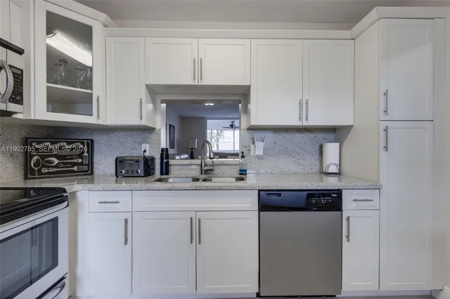 a kitchen with stainless steel appliances granite countertop a sink and cabinets