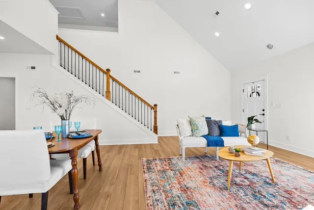 a kitchen with stainless steel appliances granite countertop a stove top oven a sink a dining table and chairs with wooden floor