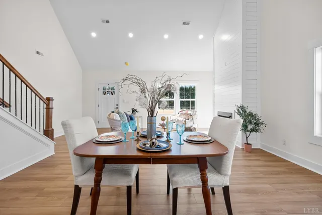 a view of a hallway with wooden floor and a bathroom