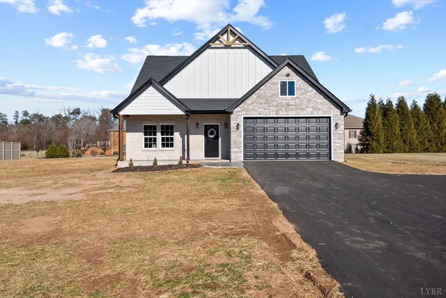 a living room with furniture potted plant and kitchen view