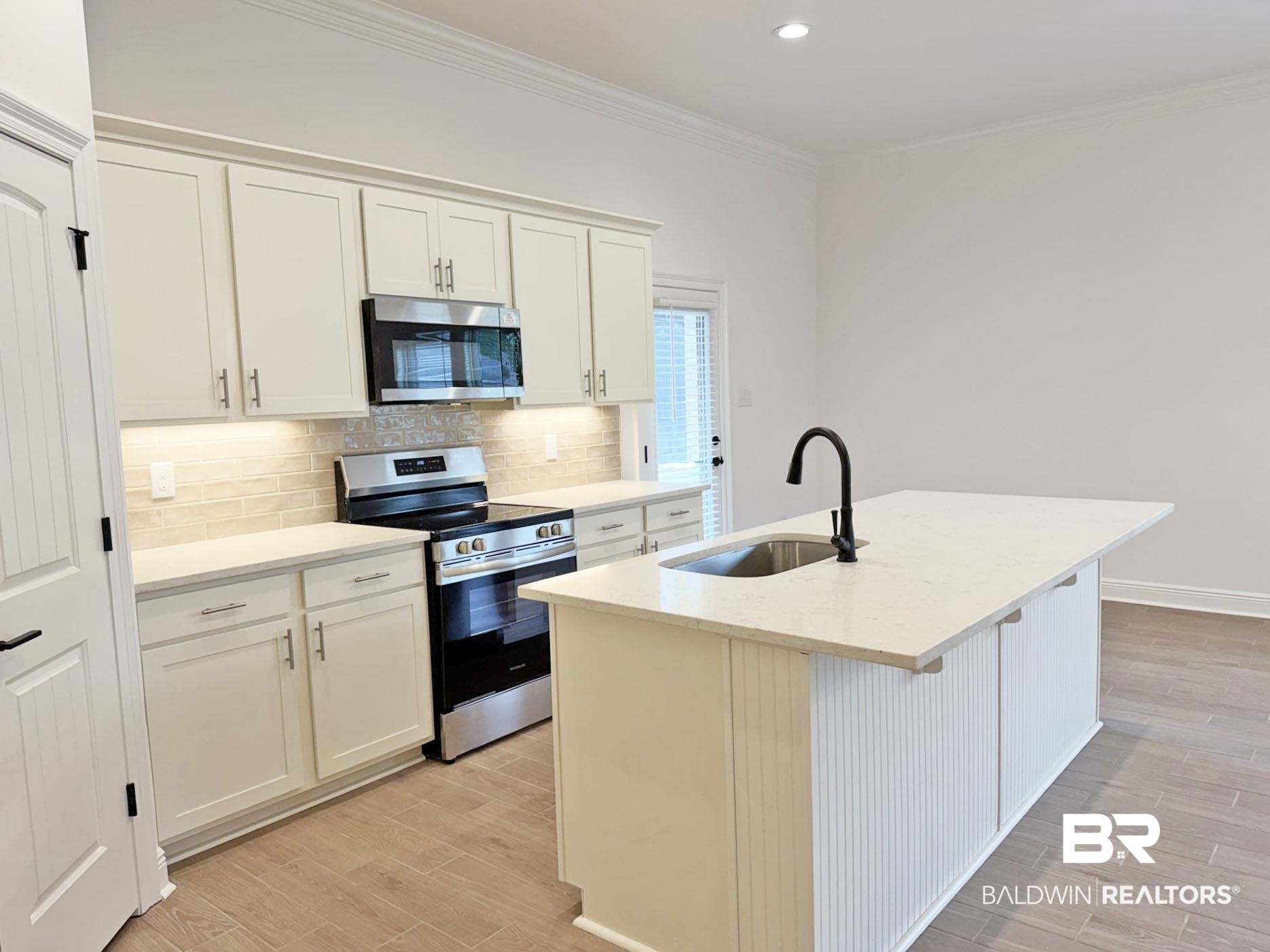 1753 Breckinridge Place Foley, AL 36535 - Photo 2 of 24 Modern kitchen featuring white shaker cabinetry, stainless steel appliances, a tile backsplash, and quartz countertops
