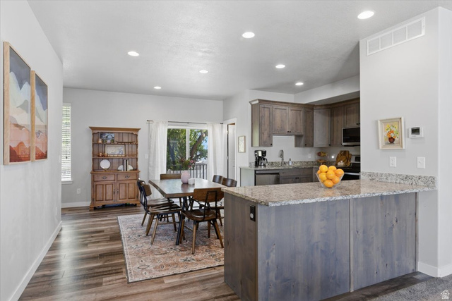 370 West Knights Lane Layton, UT 84041 - Photo 13 of 31 Open-concept living area with wood-finish flooring, recessed lighting, and a modern kitchen featuring wood-finish cabinetry, stainless steel appliances, and granite countertops