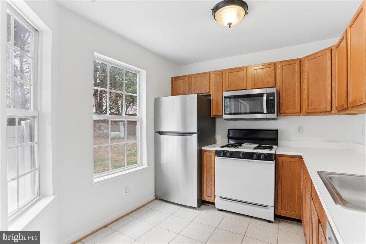 631 Constellation Square Southeast, Unit D Leesburg, VA 20175 - Photo 6 of 22 a kitchen with a refrigerator a stove a microwave and cabinets