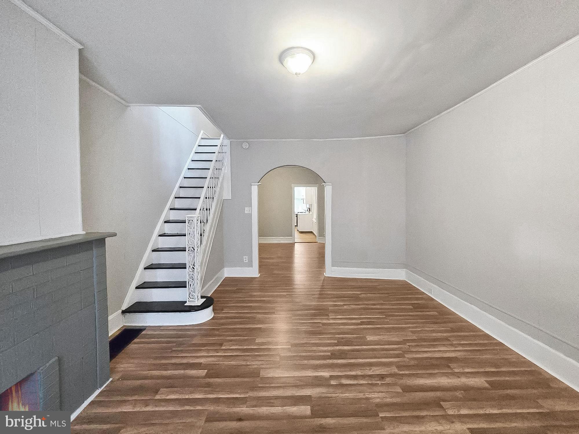 a view of a hallway with wooden floor and staircase