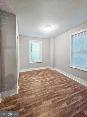 a big room with wooden floor and windows