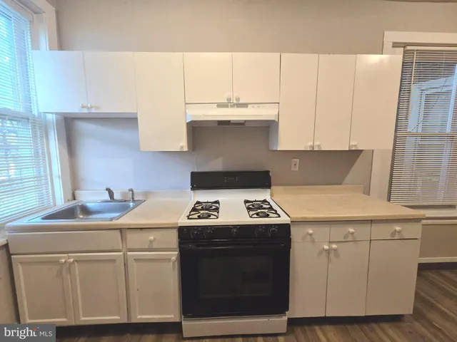 a kitchen with a stove and white cabinets