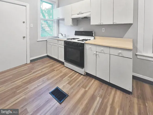 a kitchen with a sink cabinets and wooden floor